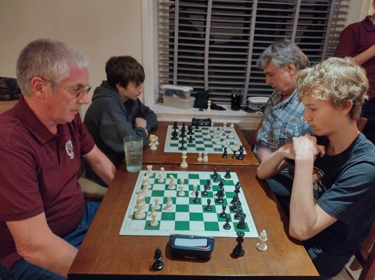 A group of men playing chess

Description automatically generated